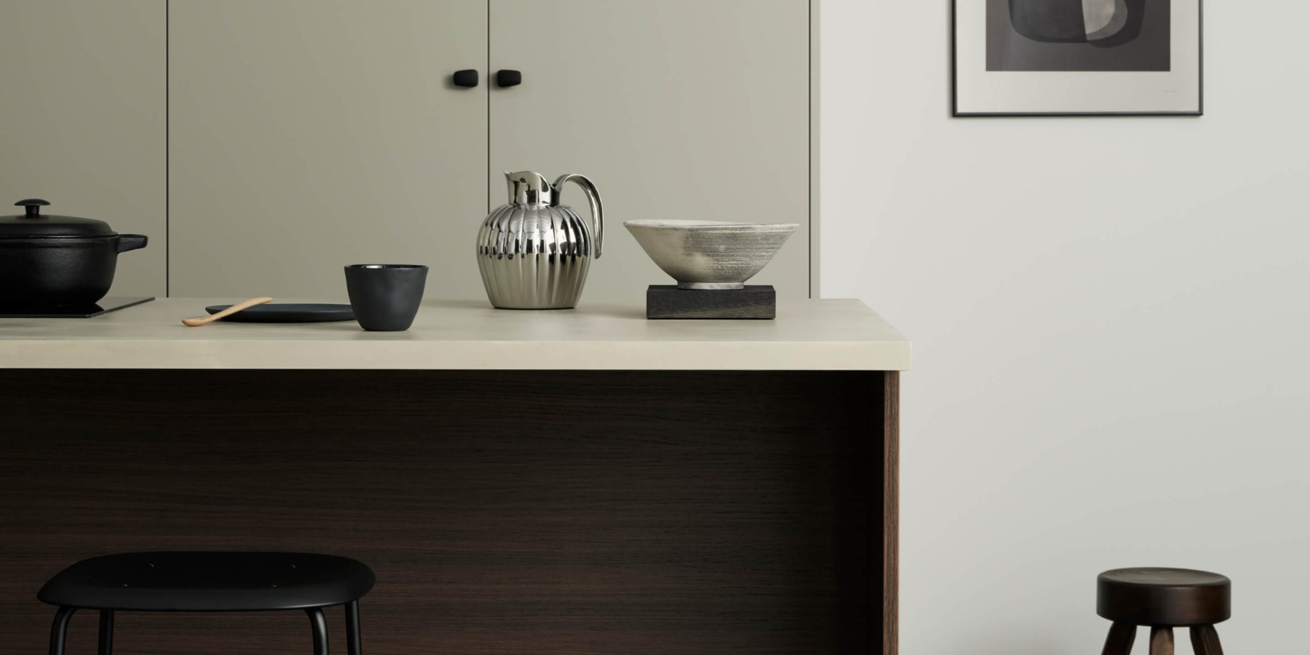 Högskåp i beige med en köksö i mörk ek-laminat framför