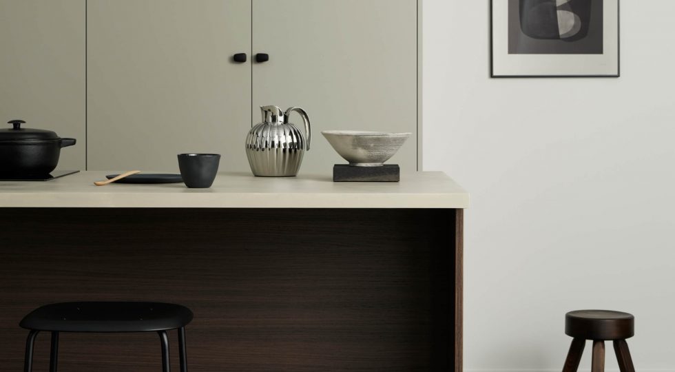 Högskåp i beige med en köksö i mörk ek-laminat framför