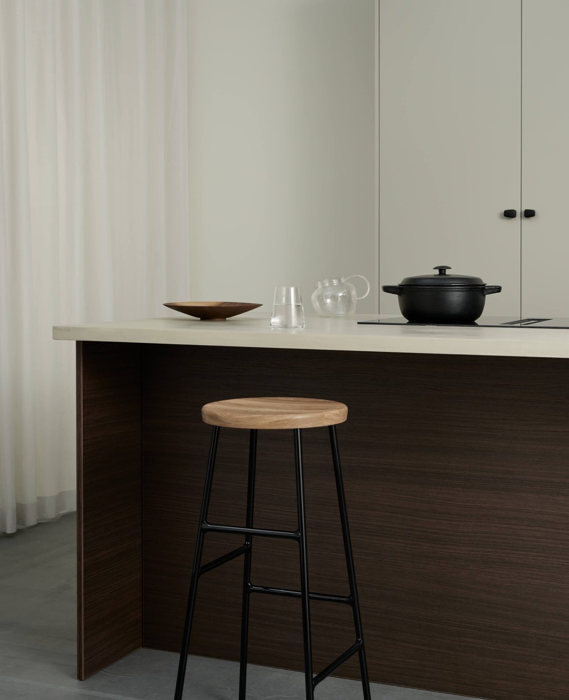 Köksö i mörk ek-laminat med gryta, glas och träfat