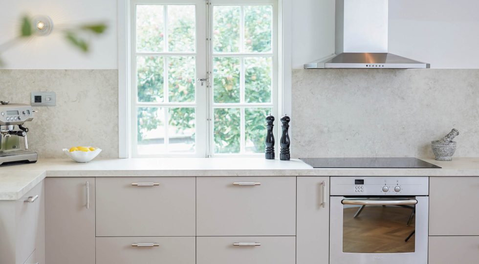 Köksluckor i färgen Ljung som passar fint med bänkskivan i ljust stenmönster