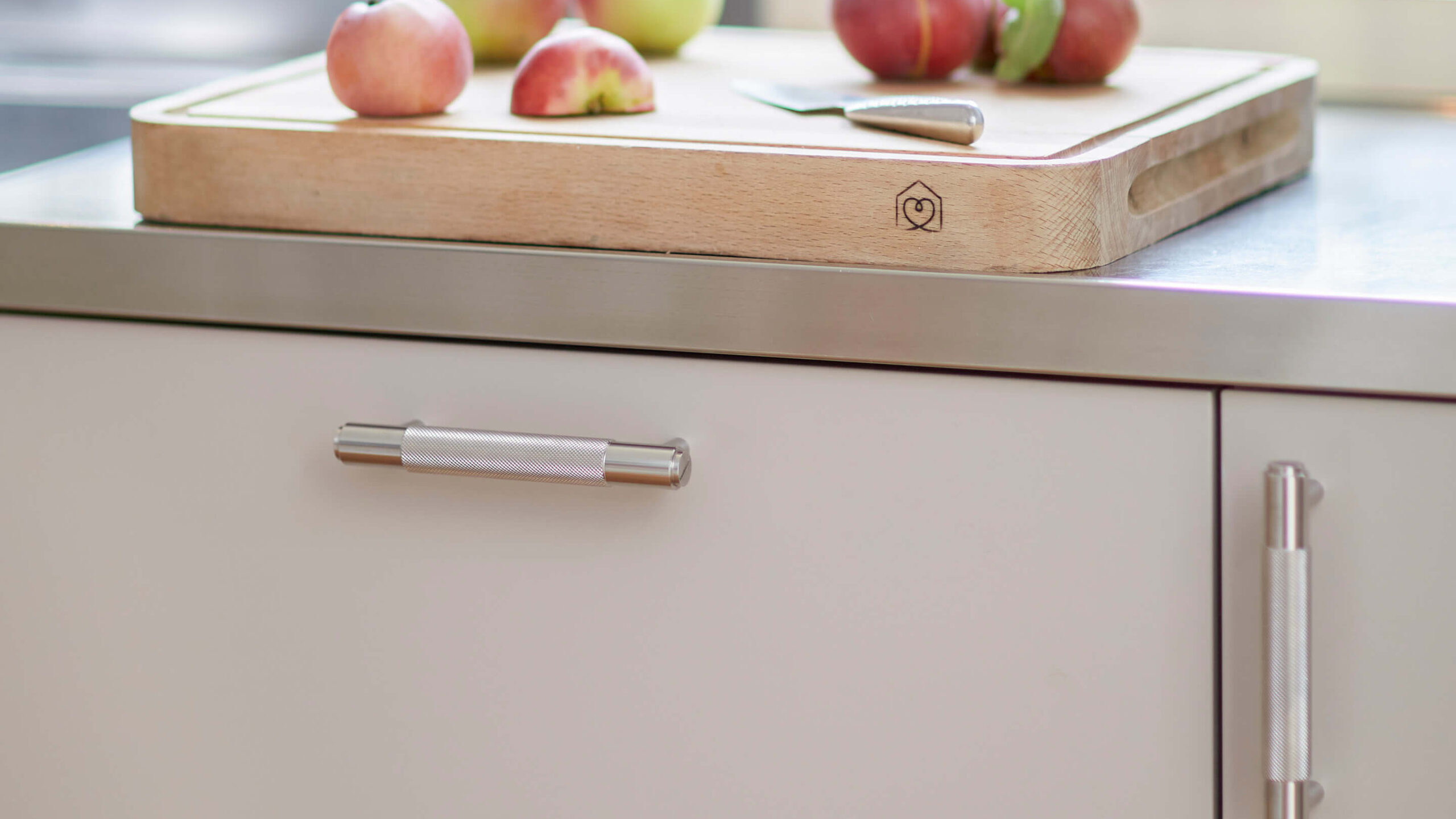 Varmgrå kökslucka i färgen Ljung tillsammans med handtag i rostfritt